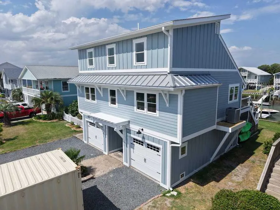 Aerial of a two-story blue sided home with garage